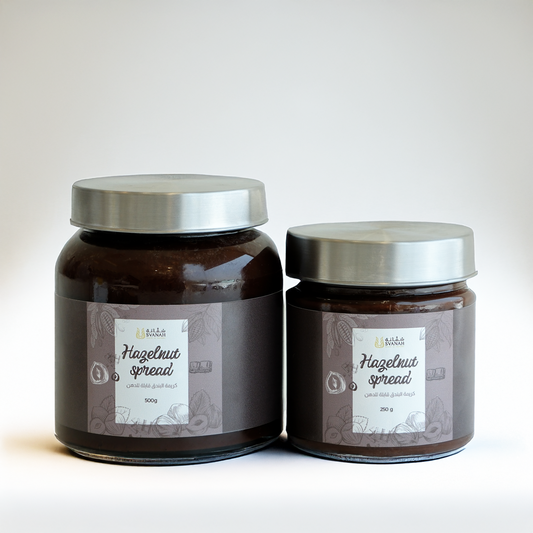 Two jars of hazelnut spread with silver lids on a light background