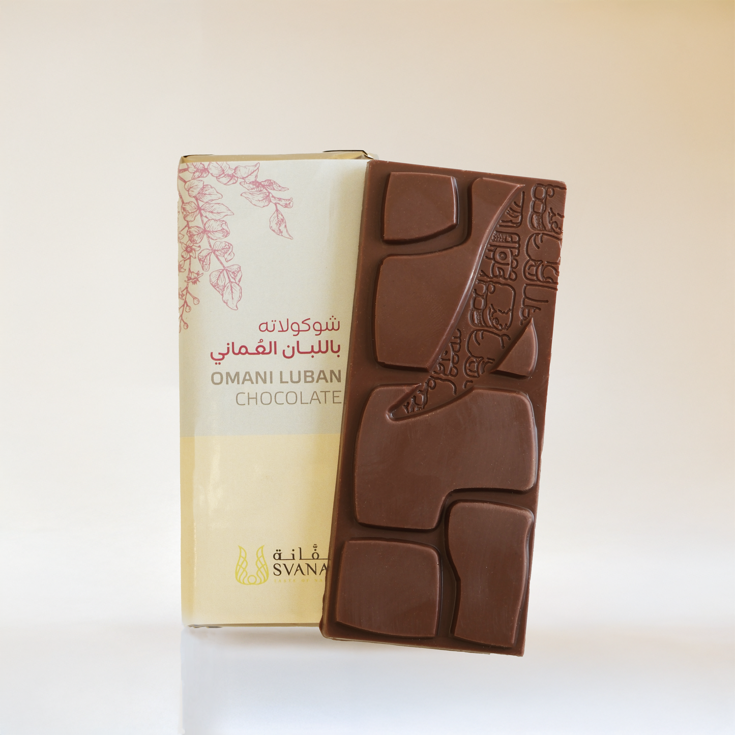 Chocolate bar with embossed design next to its packaging on a white background
