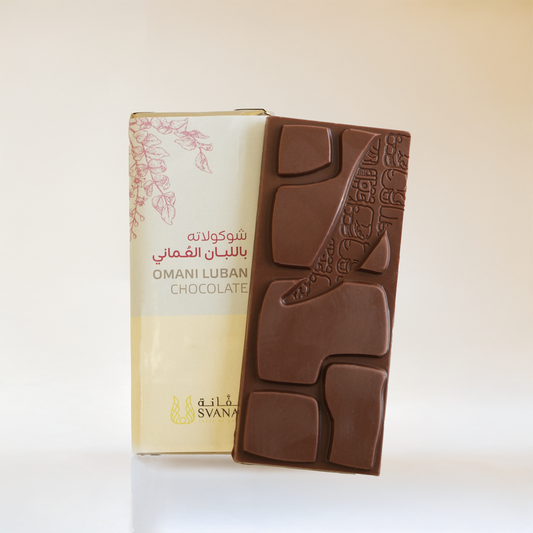 Chocolate bar with embossed design next to its packaging on a white background