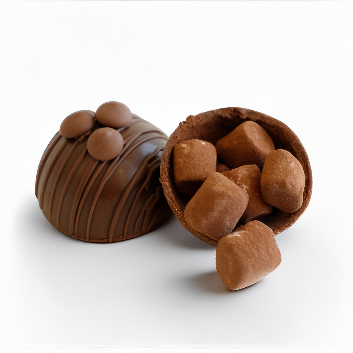 Chocolate truffles with one open showing the creme filling on a white background