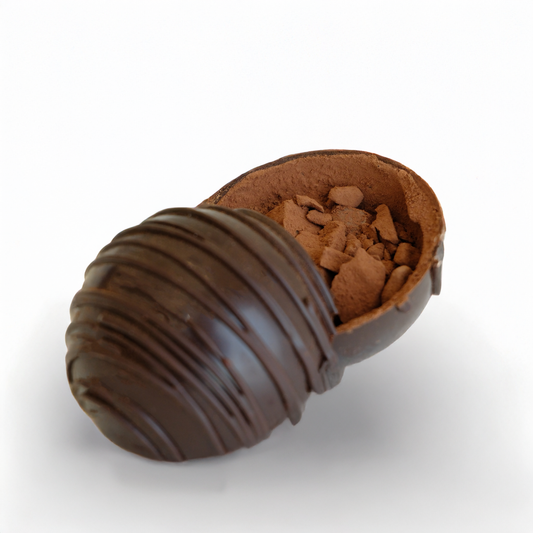 Chocolate truffle with a shell that has been partially eaten on a white background