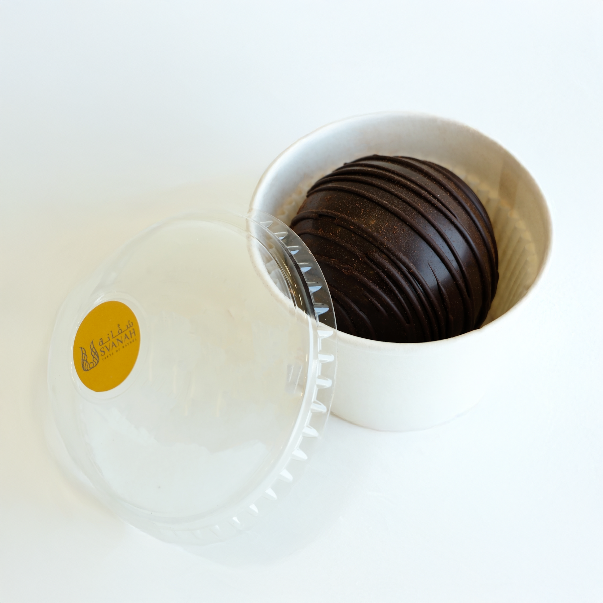 White container with a yellow label containing dark chocolate discs on a white background