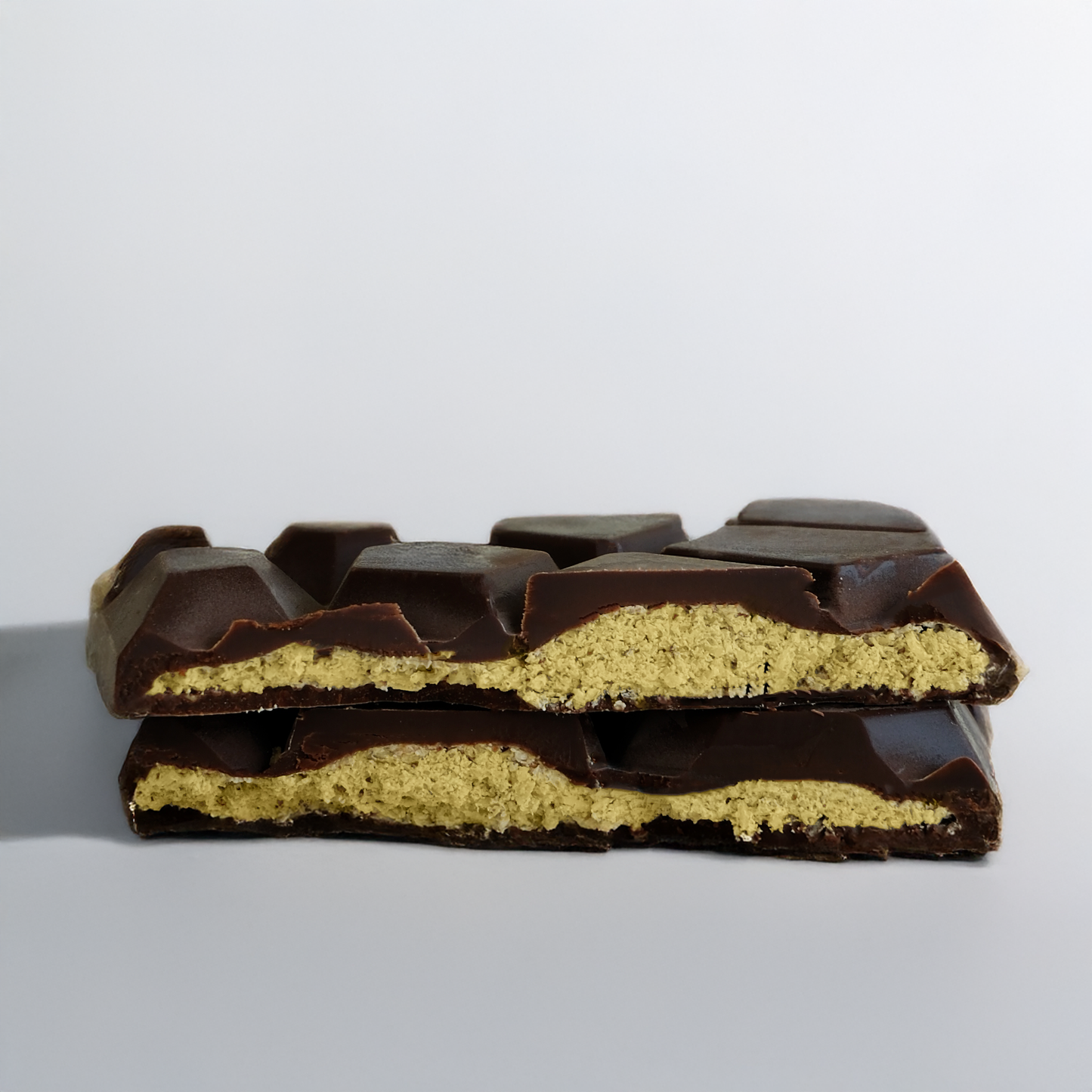 Half-eaten chocolate bar with a visible yellow filling on a gray background