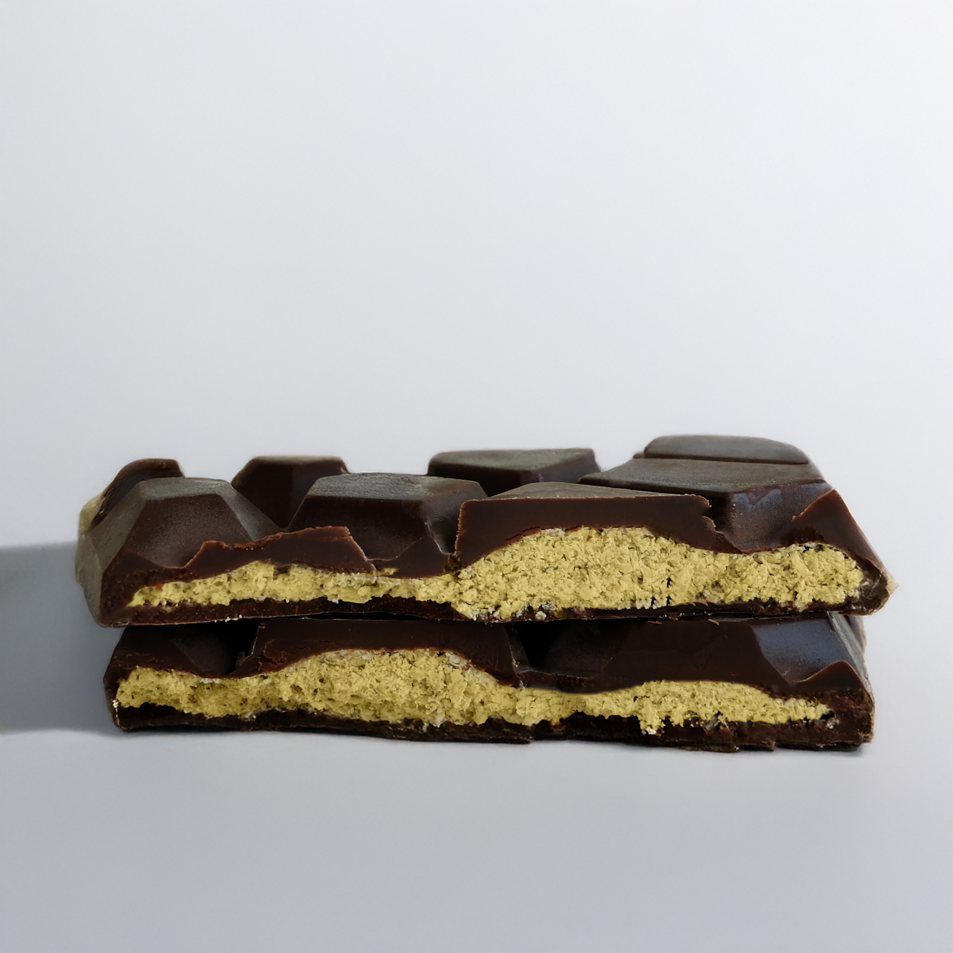 Half-eaten chocolate bar with a visible yellow filling on a gray background