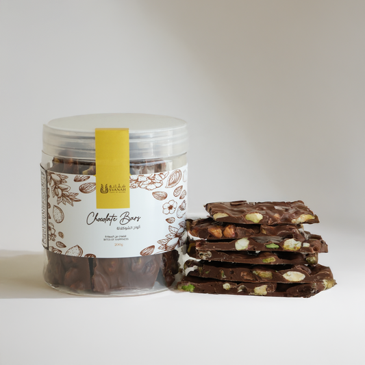 Jar of chocolate bars with a stack of chocolate bark on a white background