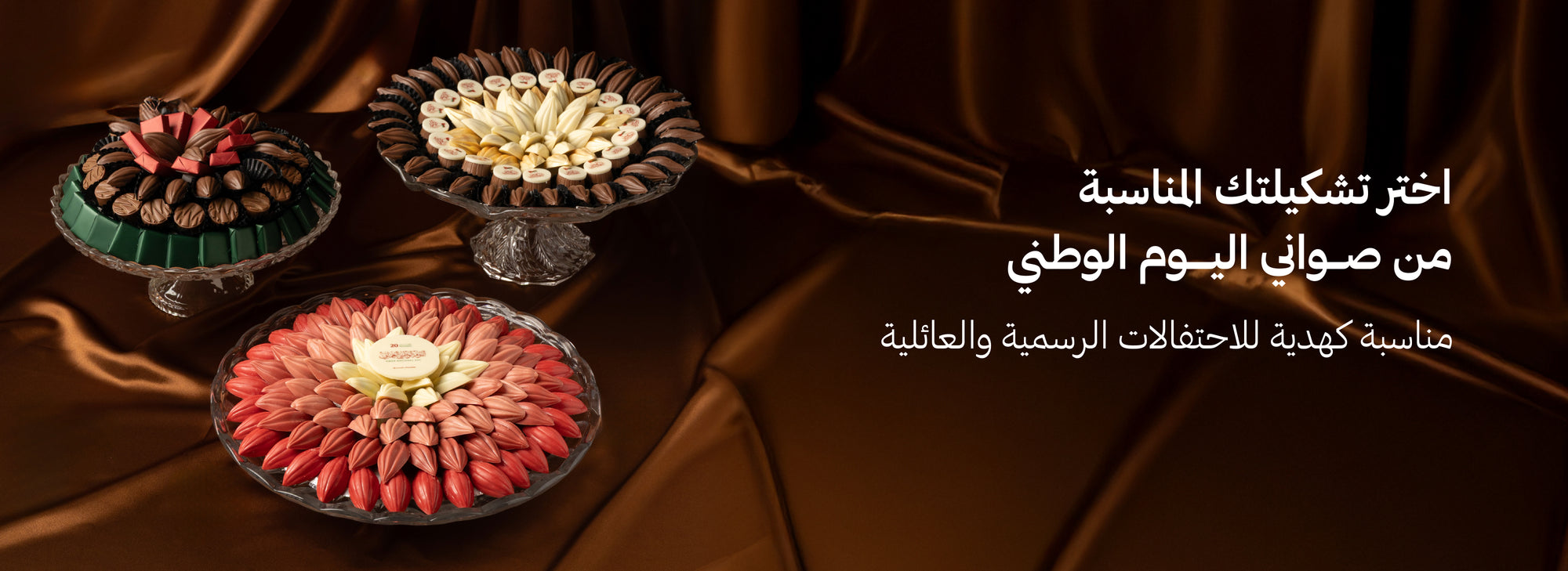 Three platters of assorted Omani National Day Chocolate trays on a brown surface.