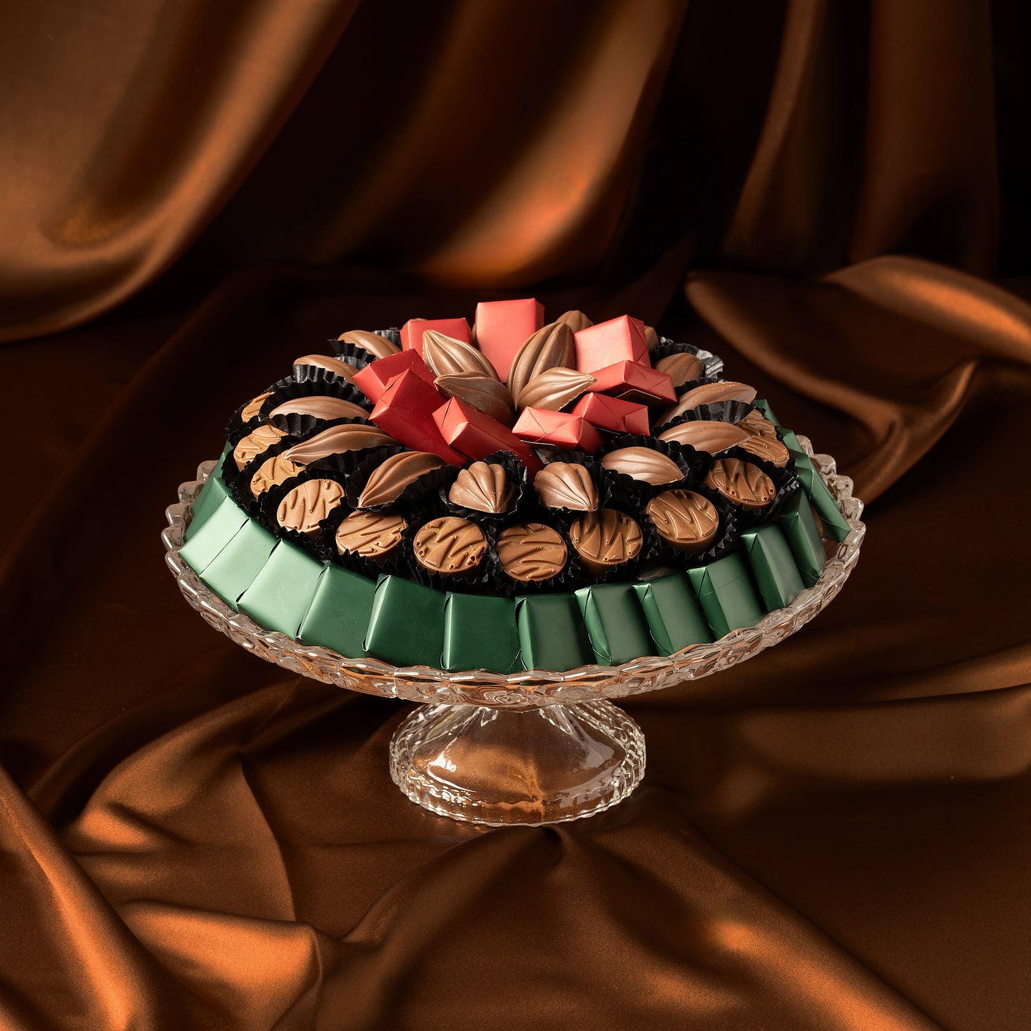 Omani National Day Chocolate Tray with red, green, and brown milk chocolates on a brown fabric background